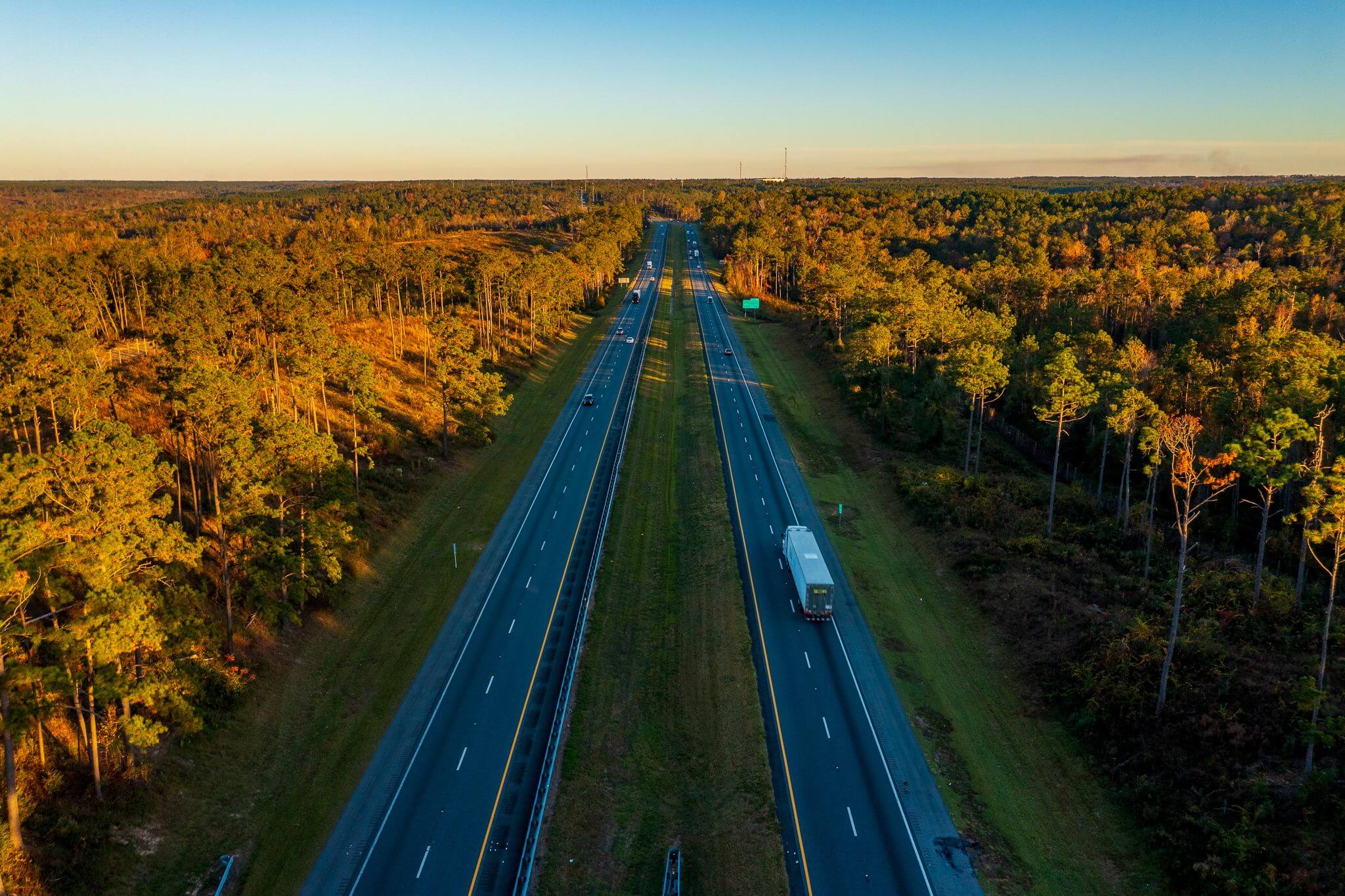Aerial view of highway surrounded by forest.