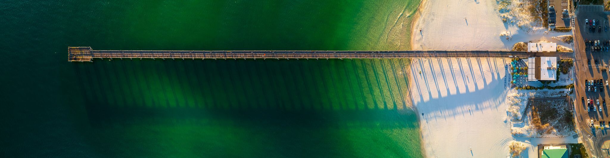 Wooden pier stretching out into emerald green waters.