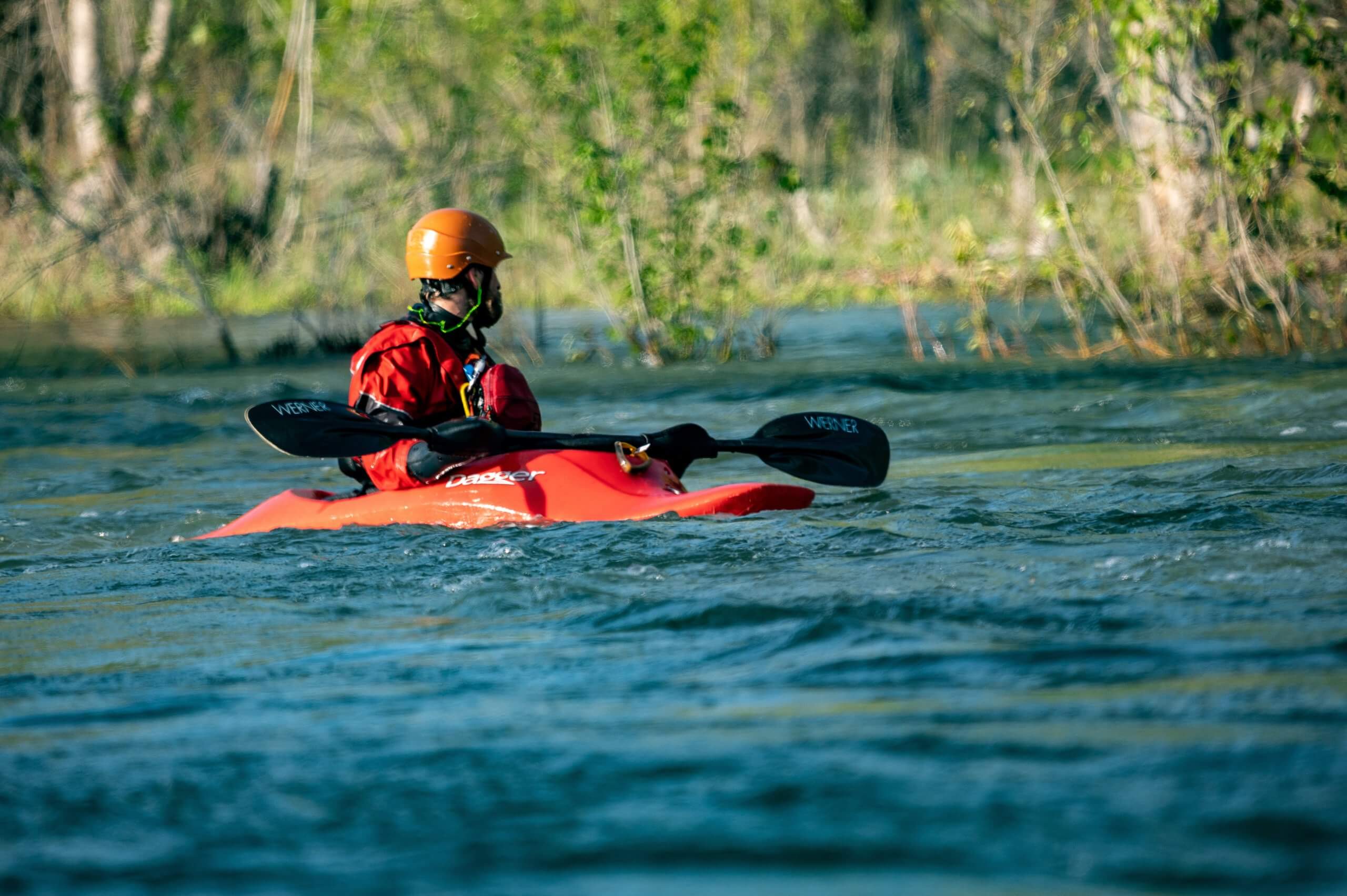 Person kayaks down river.