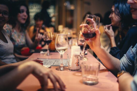 People drinking wine at dinner table.